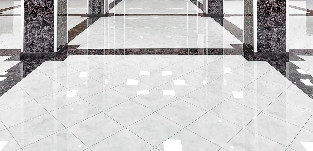 Polished marble floor with a geometric border reflecting overhead light