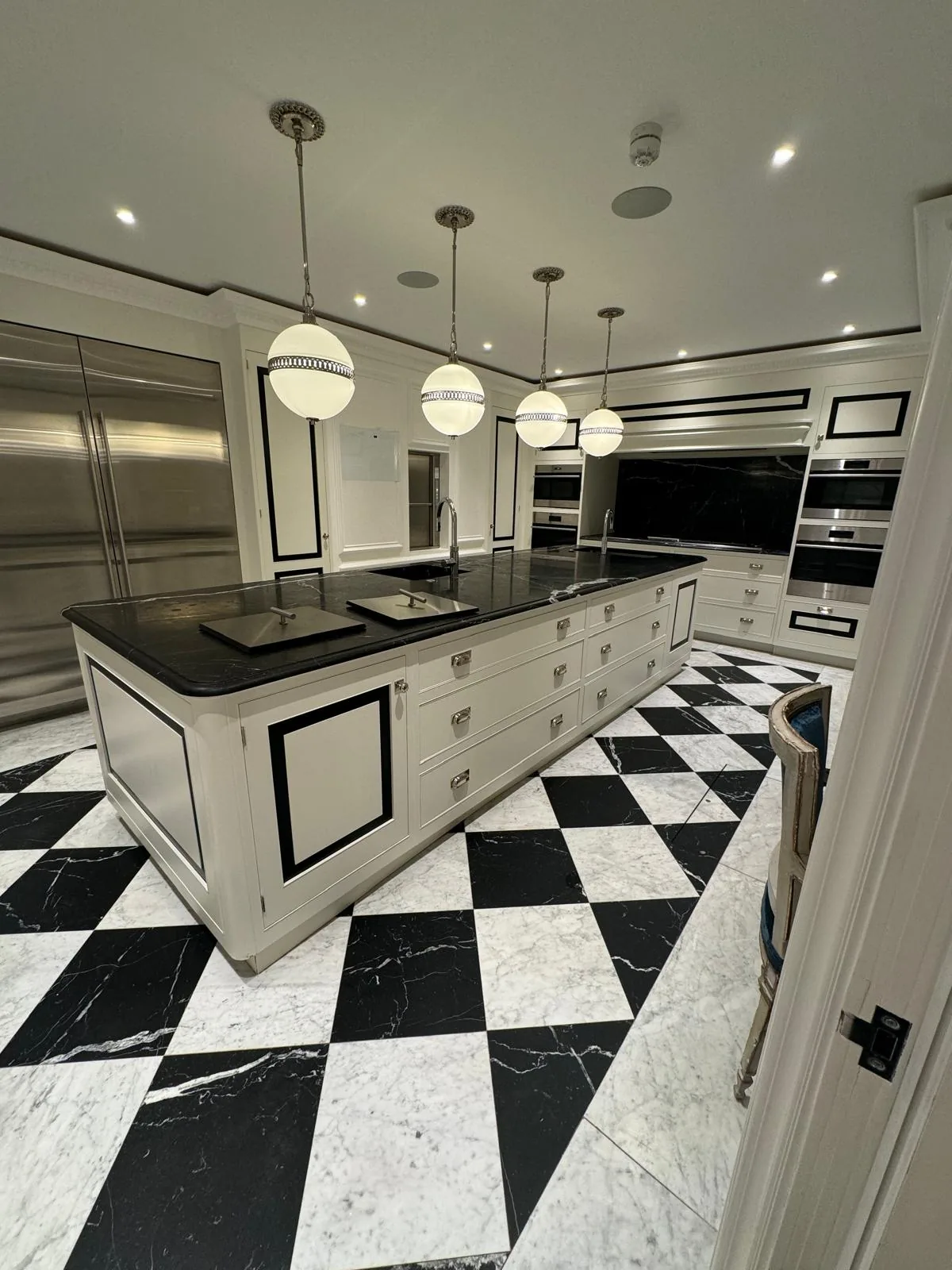 Dark and light chequered floor around a kitchen island