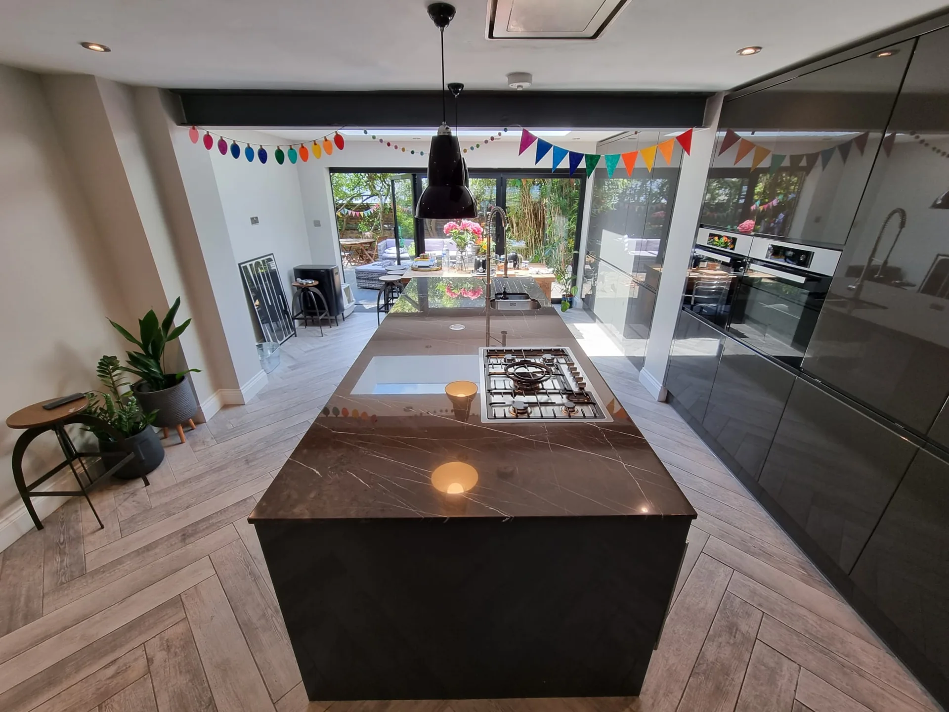 Dark stone kitchen island with a reflective surface and inset hob