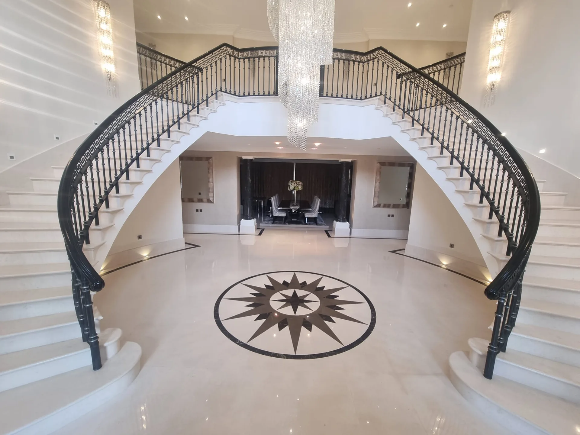 Pale entrance floor and compass medallion below a double staircase