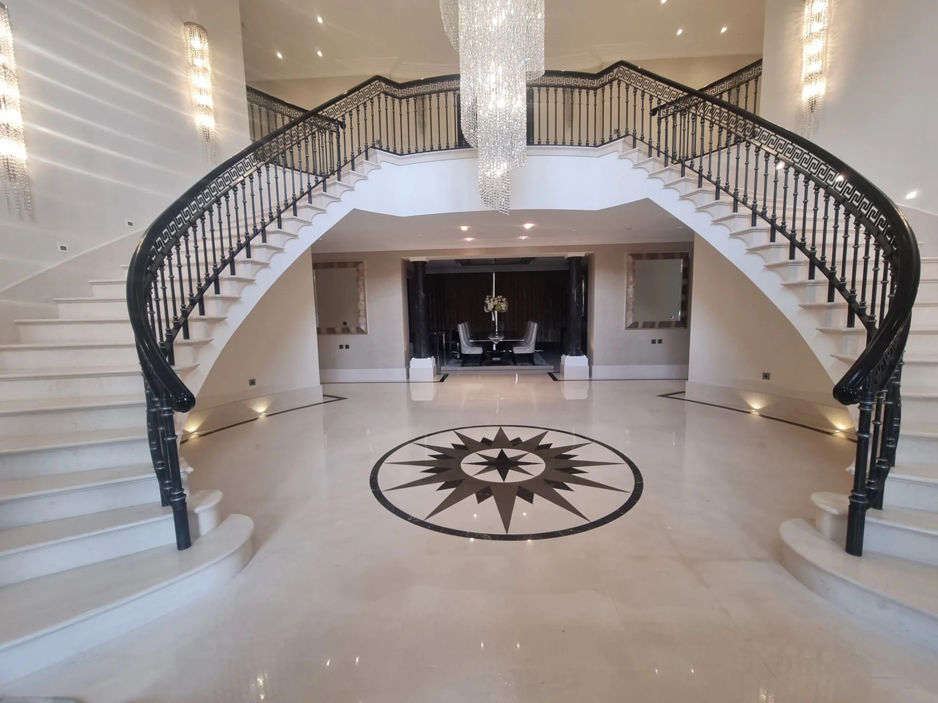 Marble entrance floor with a compass medallion beneath a double staircase