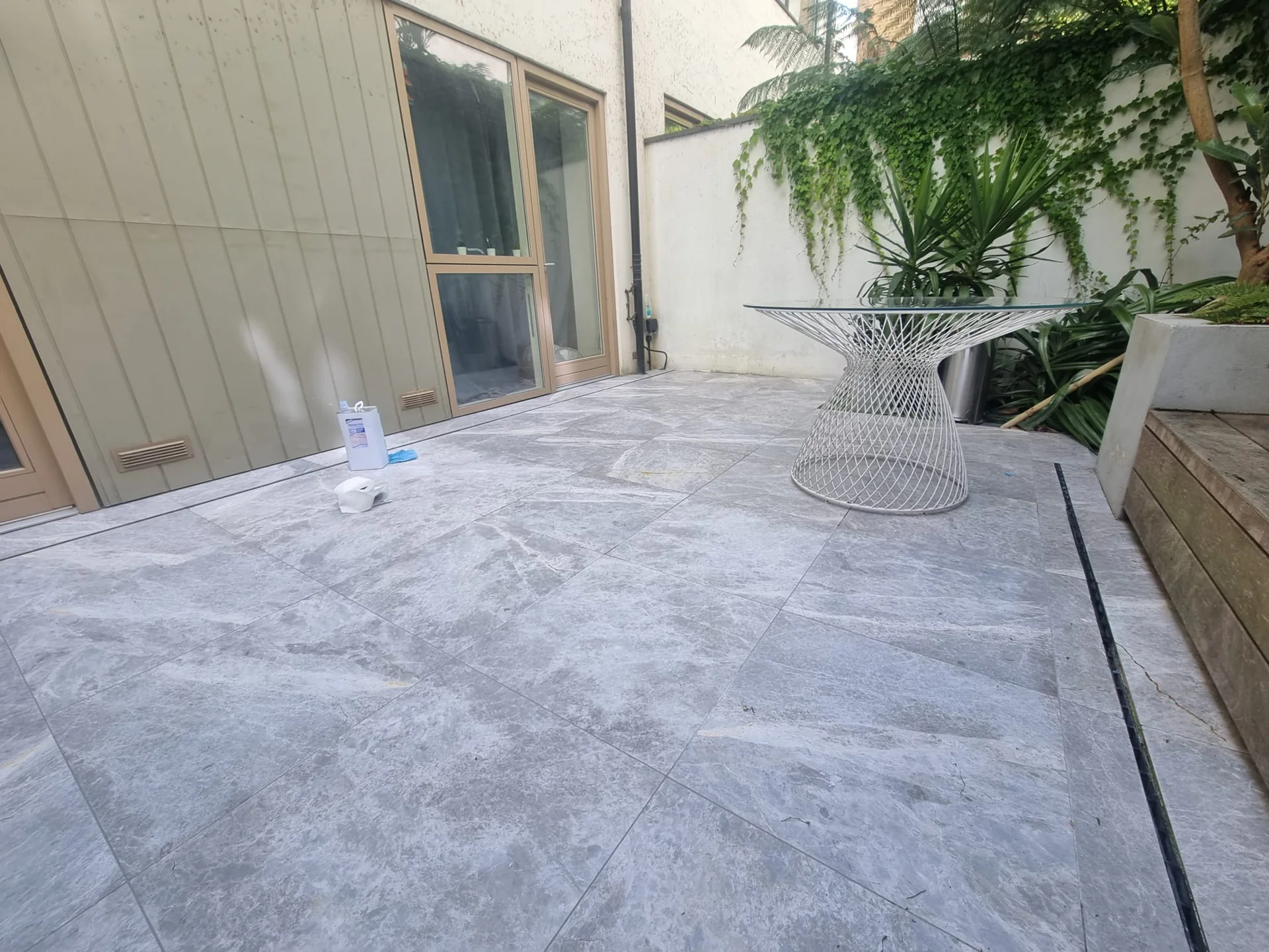 Grey veined terrace paving beside timber decking and planting