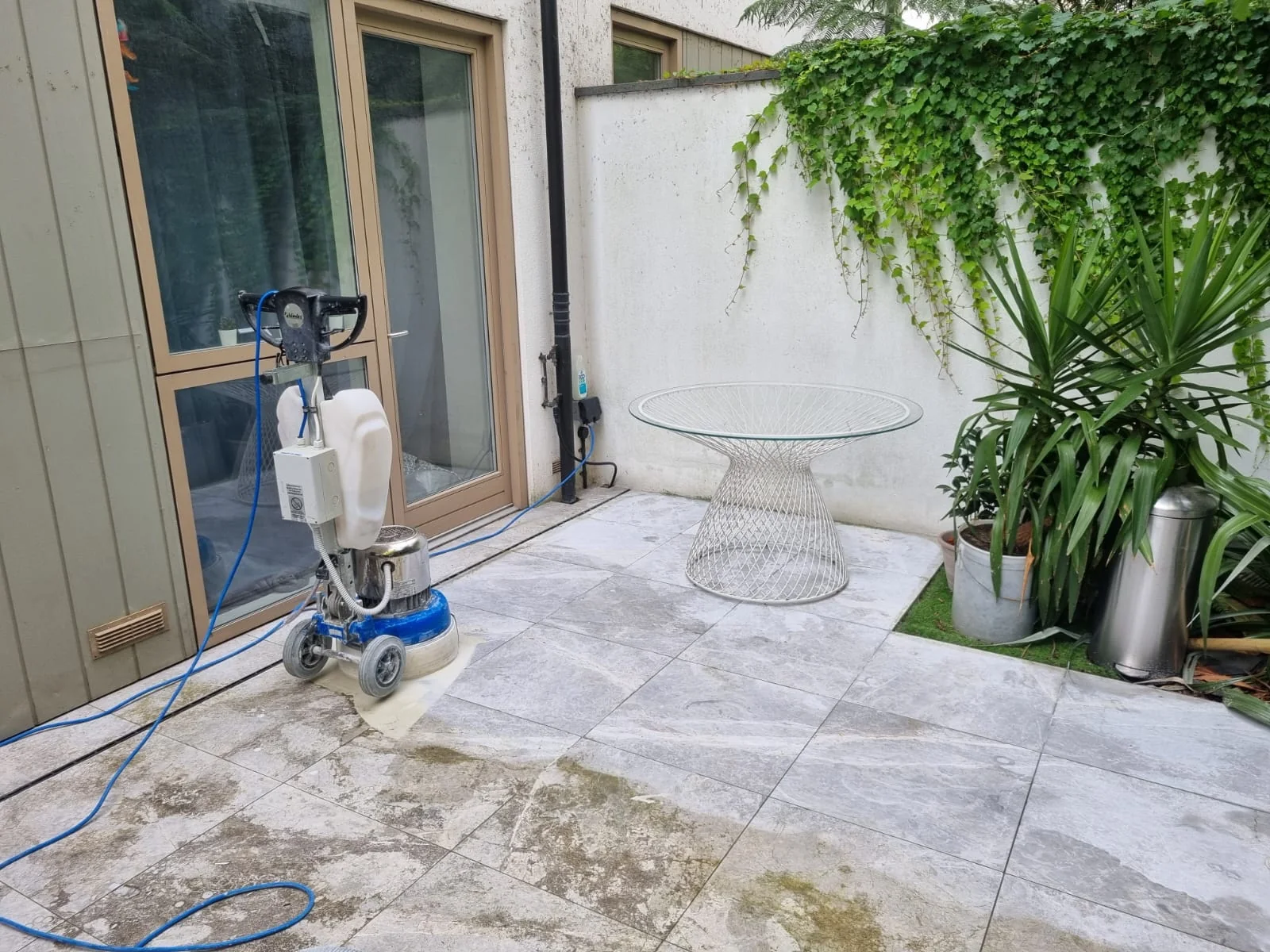 Stone terrace with cleaning equipment and protective sheeting in the work area