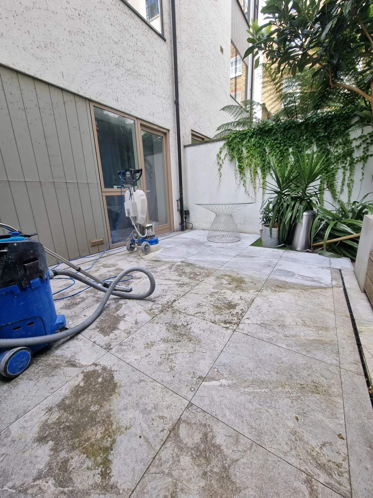 Courtyard paving beside timber decking, with equipment in the working area
